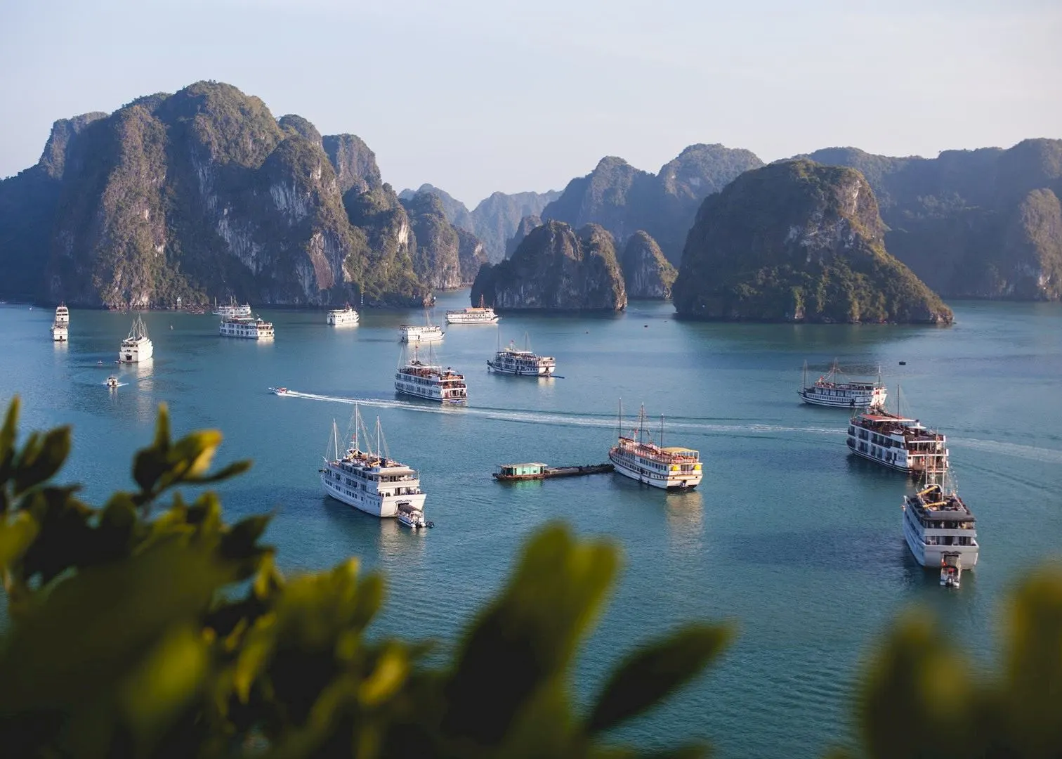 Cruise boats lie at anchor among steep limestone islets in Ha Long Bay.