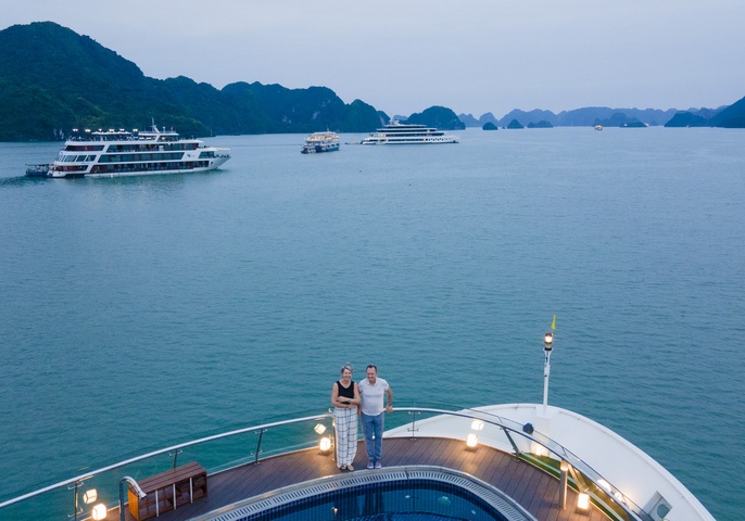 Couple on cruise bow Ha Long Bay at dusk
